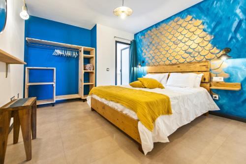 a blue bedroom with a bed and a blue wall at Cotillo Ocean Waves 1 in Cotillo