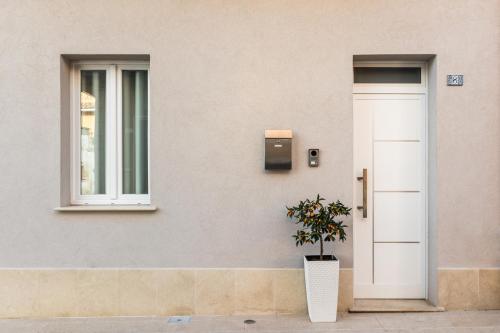 a building with a door and a potted plant at Trisina Rooms in Avola