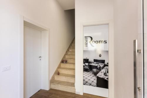 a hallway with a room with a bed and stairs at Trisina Rooms in Avola