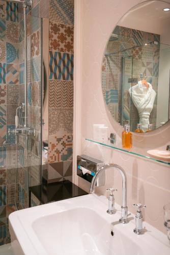 a bathroom with a sink and a mirror at Ermitage de l'Oasis & Spa - Cannes Mandelieu in Mandelieu-la-Napoule