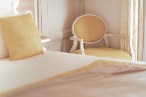 a bedroom with a chair and a bed with a pillow at Ermitage de l'Oasis & Spa - Cannes Mandelieu in Mandelieu-la-Napoule