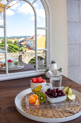 a tray of fruit on a table in front of a window at a casa da Alicia in Monforte de Lemos