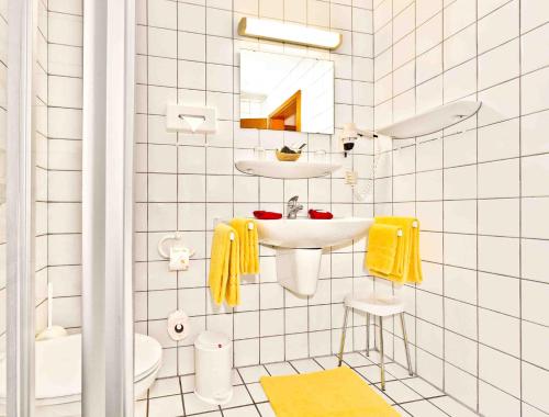 biała łazienka z umywalką i toaletą w obiekcie Hotel Merian Rothenburg w mieście Rothenburg ob der Tauber