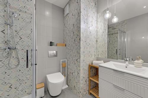 y baño con ducha, aseo y lavamanos. en Downtown Apartments Śląska 12 en Gdansk