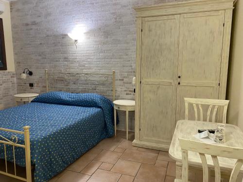a bedroom with a bed and a table and chairs at Hotel Villa Del Parco in La Maddalena