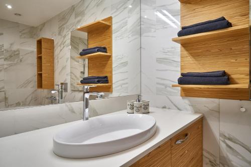 een witte badkamer met een wastafel en een spiegel bij EMI Apartment in Rīga