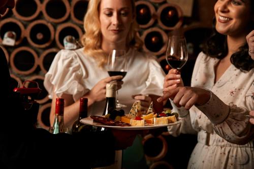 a group of people holding wine glasses and a plate of food at The K Club in Straffan