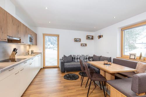 a kitchen and living room with a table and a couch at Apart Auszeit in Niederthai