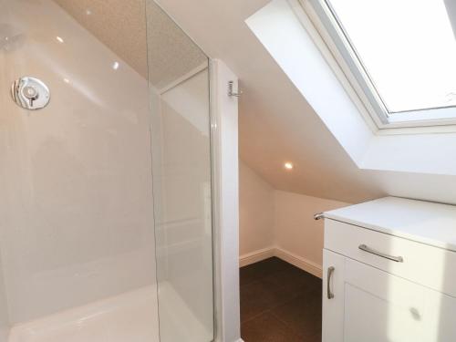 uma casa de banho com um chuveiro e uma clarabóia em Stable Cottage em Brampton