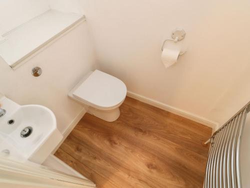a bathroom with a toilet and a sink at Stable Cottage in Brampton