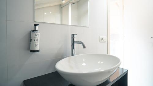 La salle de bains est pourvue d'un lavabo blanc et d'une bouteille de vin. dans l'établissement Smartr Madrid Atocha, à Madrid