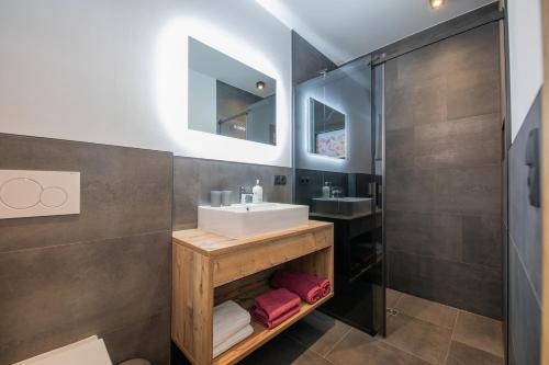 uma casa de banho com um lavatório e um chuveiro em Mountainlights Apartment em Neustift im Stubaital