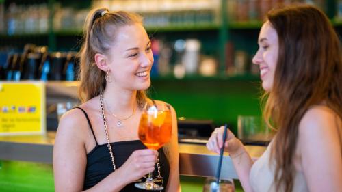 two girls sitting at a bar holding a wine glass at JO&JOE Vienna in Vienna
