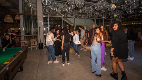 a group of people dancing in a room with a pool table at JO&JOE Vienna in Vienna