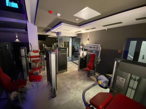 a room with a gym with red chairs and machines at Hotel Sanova in Jarosław