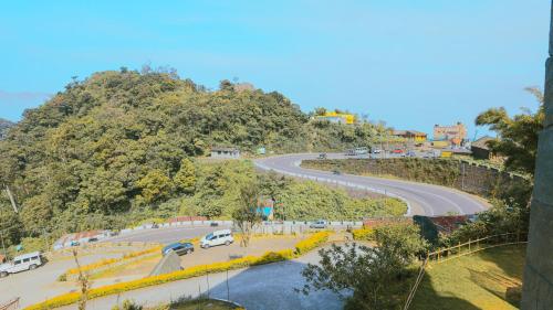 a winding road on a hill with cars on it at Shola Crown Resort - Munnar in Chinnakanal