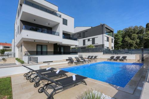 una casa con piscina al lado de un edificio en Villa Ankora 2 with heated pool, en Biograd na Moru