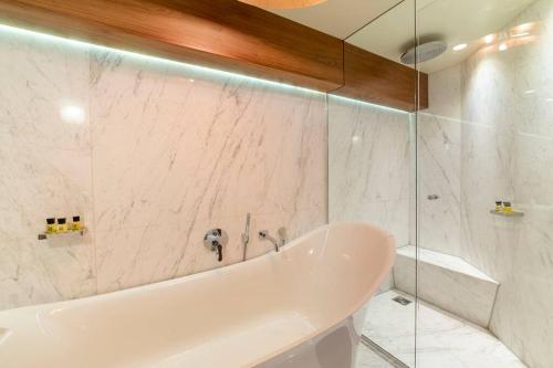 a white bathroom with a tub and a shower at Westcourt by RMG Apartments in Harrogate
