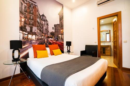 1 dormitorio con 1 cama grande y una pintura en la pared en Smartr Madrid Atocha, en Madrid