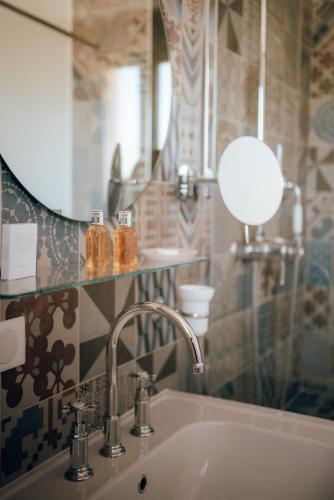 a bathroom with a sink and a mirror at Ermitage de l'Oasis & Spa - Cannes Mandelieu in Mandelieu-la-Napoule