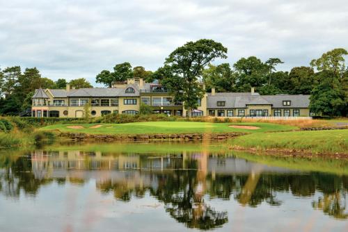 a house on a golf course next to a lake at The K Club in Straffan