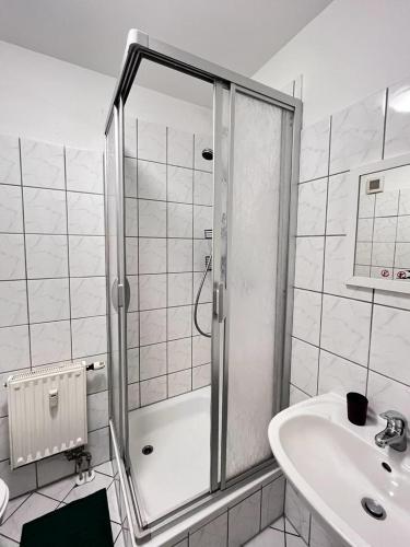 La salle de bains est pourvue d'une douche et d'un lavabo. dans l'établissement Ruhe und Komfort im Zentrum von Leipzig, à Leipzig