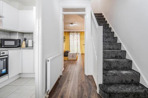 a stairway leading to a kitchen and a living room at Lovely House in Dagenham / Barking with free parking, WiFi & Garden in Dagenham