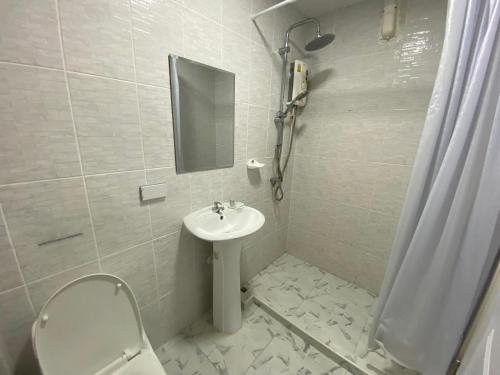 La salle de bains est pourvue d'un lavabo, de toilettes et d'un miroir. dans l'établissement Phala Shore Resort, 