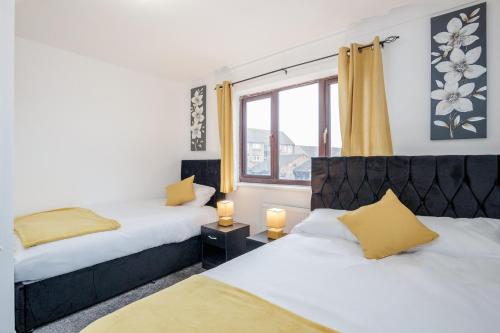 um quarto com 2 camas e uma janela em Lovely House in Dagenham / Barking with free parking, WiFi & Garden em Dagenham