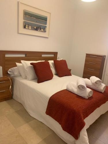 um quarto com uma cama grande e toalhas em Casa Vigon em Sanlúcar de Barrameda