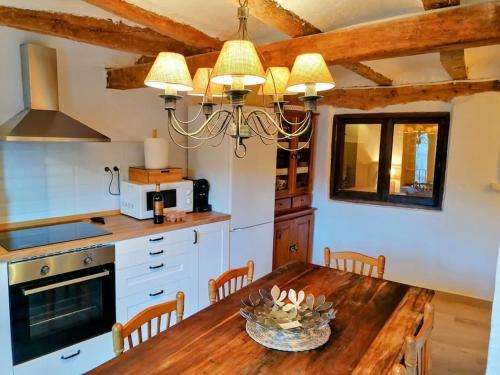 a kitchen with a wooden table and a dining room at La Casirria in Olba