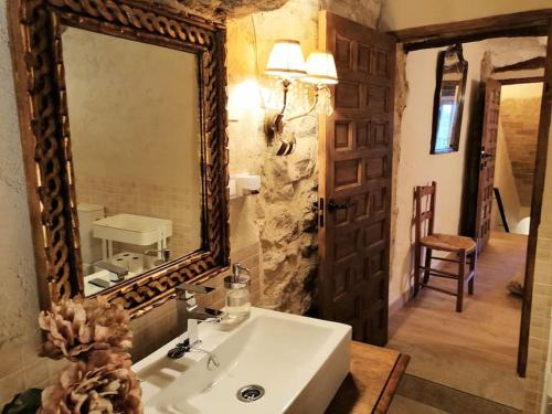 a bathroom with a sink and a large mirror at La Casirria in Olba