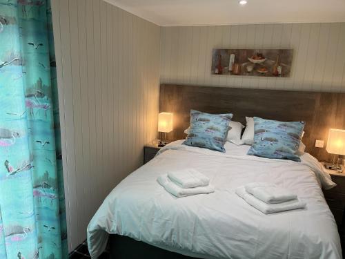 a bedroom with a bed with towels on it at Cedar Boutique Lodge-dog fishing and Spa access in York