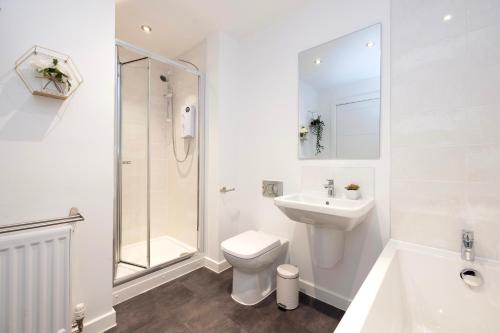 a white bathroom with a toilet sink and a shower at Stylish House with Garden and Parking in Glasgow