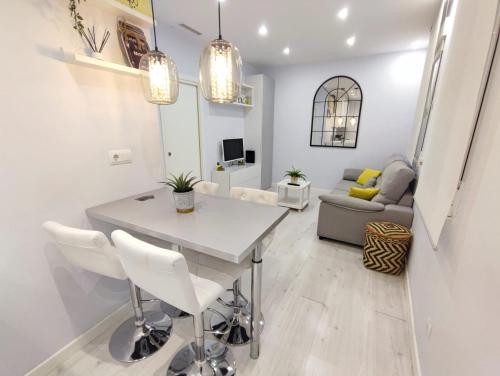 cocina y sala de estar con mesa blanca y sillas en Apartamento con encanto, en Madrid