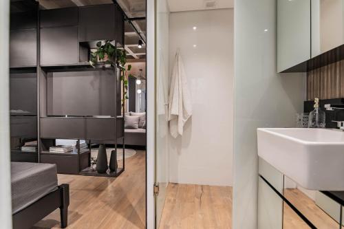 y baño con lavabo blanco y espejo. en Loft conceito com área privativa, en Belo Horizonte