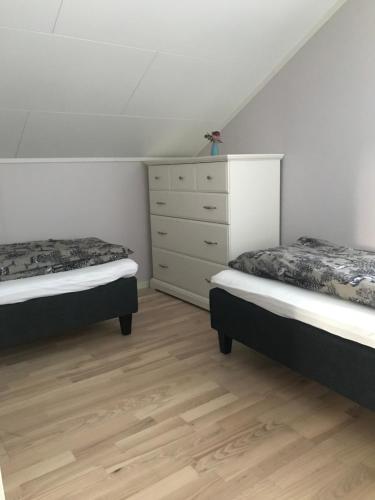 a bedroom with two twin beds and a dresser at Heggelund in Svensby