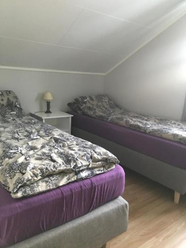 1 dormitorio con 2 camas y mesita de noche en Heggelund en Svensby