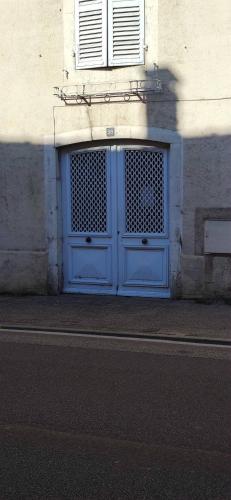 une porte bleue sur le côté du bâtiment dans l'établissement Superbe studio en résidence rue de courcelles, à Arbois