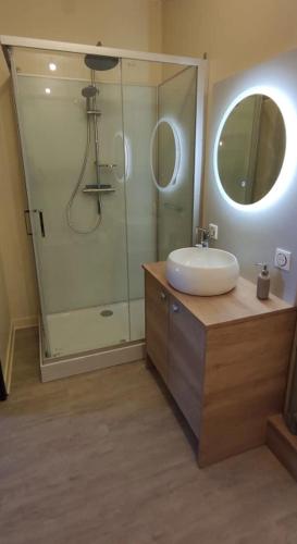a bathroom with a sink and a glass shower at Superbe studio en résidence rue de courcelles in Arbois