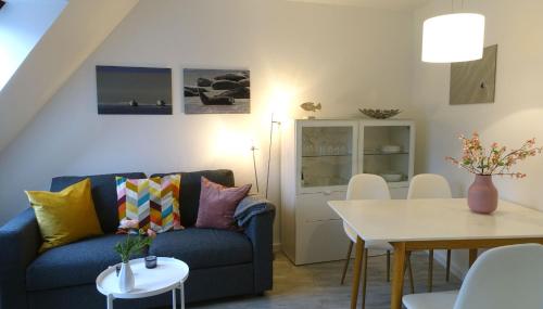 a living room with a blue couch and a table at Inselresidenz Strandburg Juist - Ferienwohnung 308 (Ref. 51039) in Juist