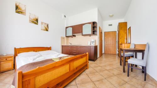 a bedroom with a bed and a table and a kitchen at Promenada I, Sun & Snow in Świnoujście