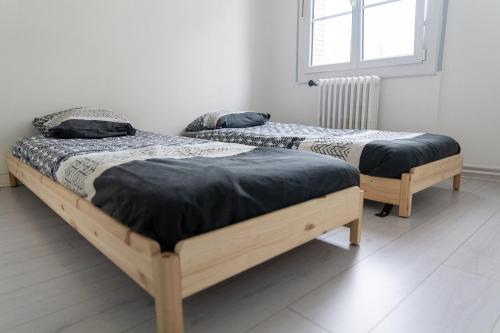 two twin beds in a room with a window at Maison au pied du château in Châteaudun