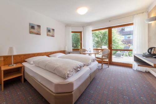 ein großes Schlafzimmer mit einem großen Bett und einem Tisch in der Unterkunft Landhaus Müller in Immenstaad am Bodensee
