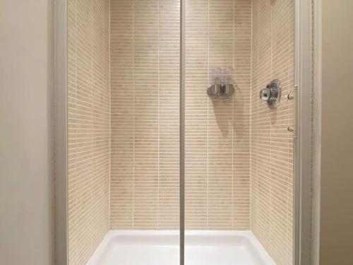 a shower with a glass door and a tub at Modern Duplex Apartment with Woodland Views in Swansea