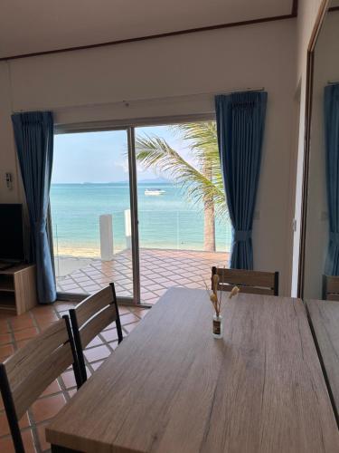 a dining room with a table and a view of the ocean at Bangrak Pier Bungalow in Bang Rak Beach