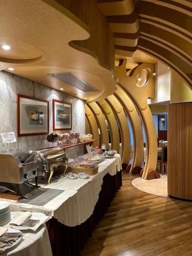 a restaurant with a long bar with white tables at Hotel Due Torri Tempesta in Noale