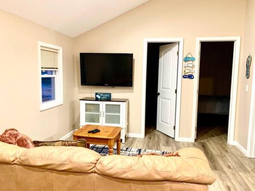 a living room with a couch and a flat screen tv at The Lighthouse-3 Bedroom with Casino Pier Gameroom in Seaside Heights
