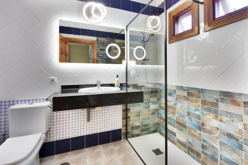 ein Badezimmer mit einem Waschbecken, einem WC und einem Spiegel in der Unterkunft CASA DANEO in Playa Blanca