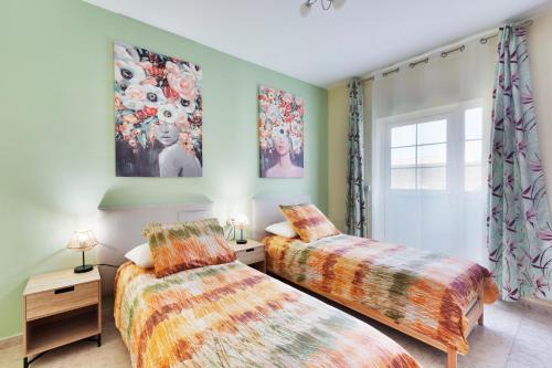 2 Betten in einem Zimmer mit grünen Wänden in der Unterkunft CASA DANEO in Playa Blanca